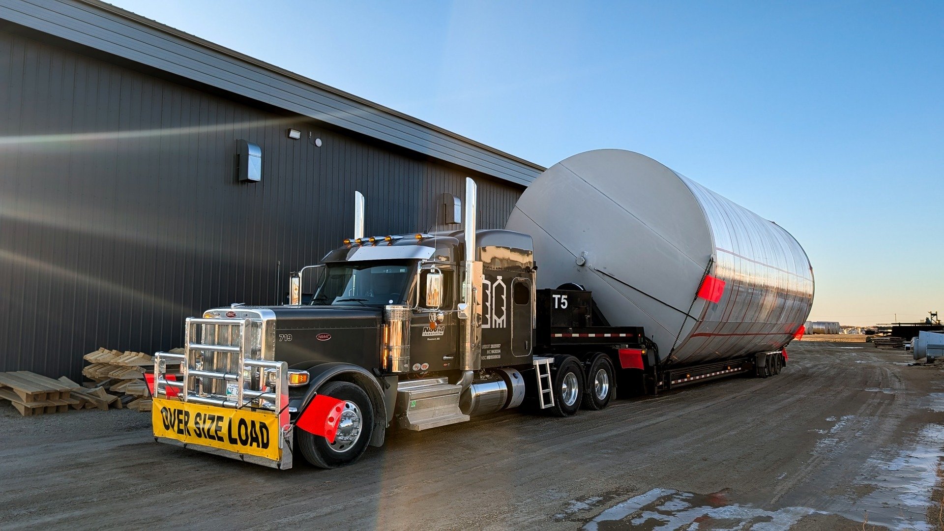 novid peterbilt semi with stainless flat bottom tank on tilt trailer