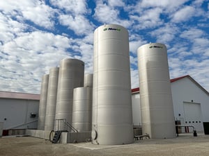 novid stainless steel flat bottom liquid storage tanks with blue cloudy sky